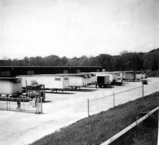 Black and white historical Case Enterprises yard photo with trailers